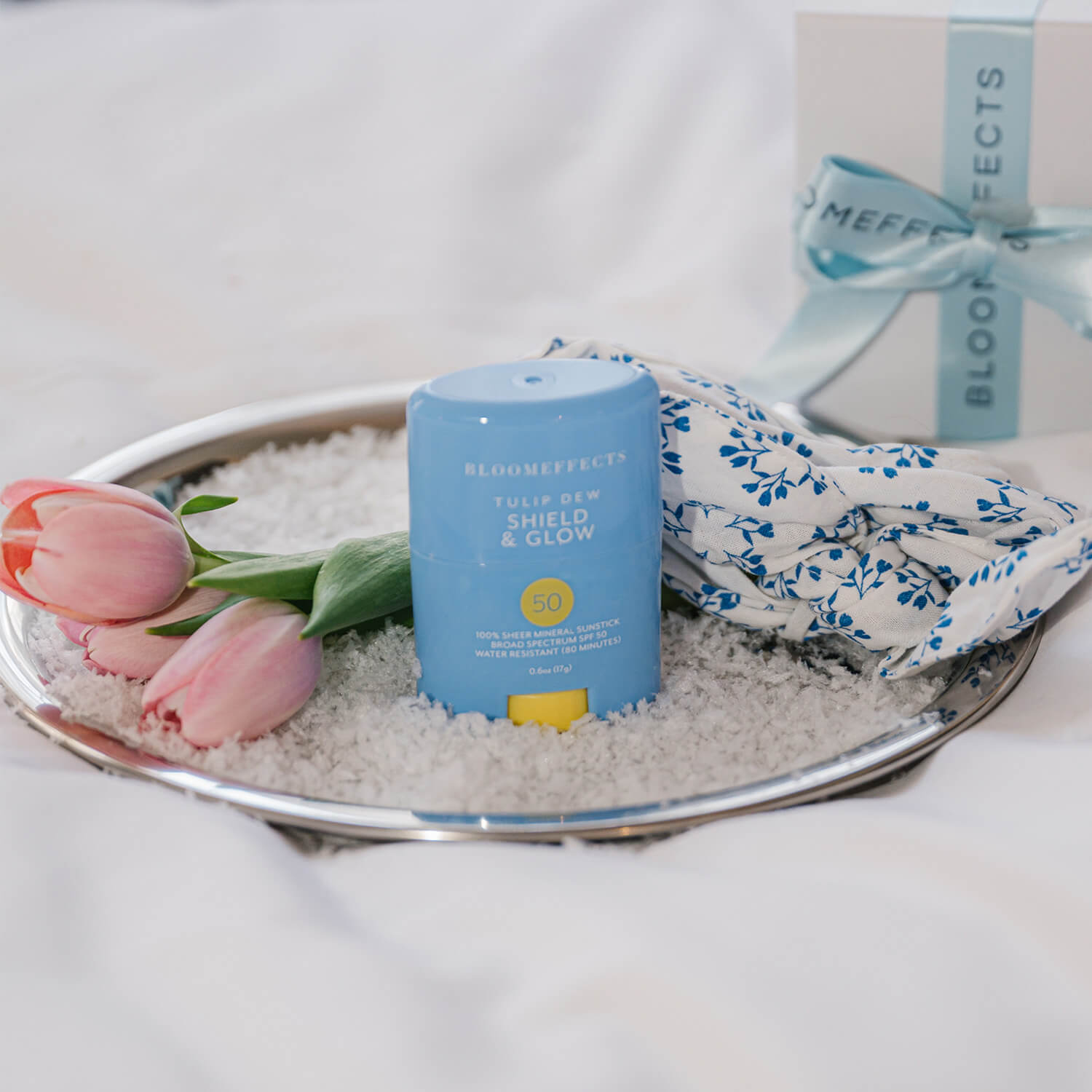 Blue skincare product with floral elements on a tray