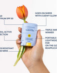 Hand holding Bloomeffects Tulipscreen Shield & Glow sunstick with an orange tulip. Callouts: Broad Spectrum SPF 50, mineral active protection, water resistant for 80 mins, goes on sheer with a dewy glow, triple award winner, portable and lightweight for on-the-go reapplication