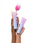 Two tubes of Bloomeffects Cleansing Jelly held by a hand with a pink tulip in the background.