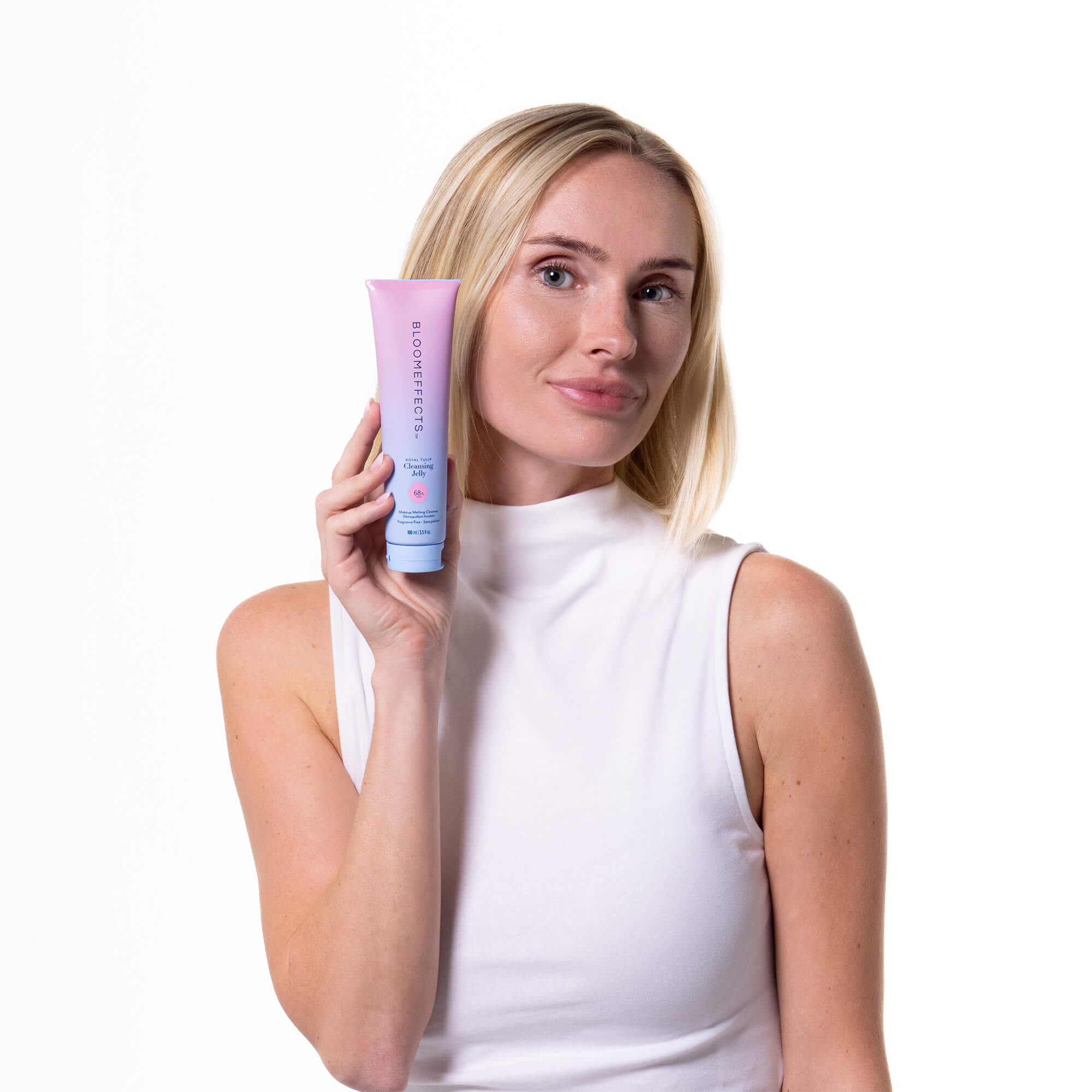 Woman holding a tube of Bloomeffects Cleansing Jelly product against a white background