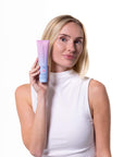 Woman holding a tube of Bloomeffects Cleansing Jelly product against a white background