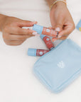 Person holding a Bloomeffects makeup bag with lip products on a light background