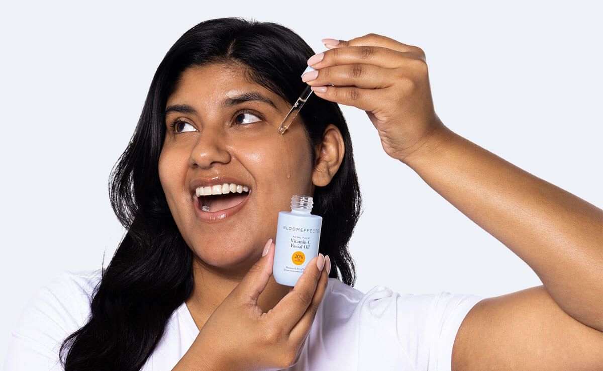 Woman applying Bloomeffects VItamin C Oil to her face
