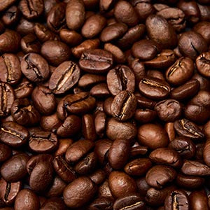 A close-up pile of roasted coffee beans in rich dark brown tones, filling the entire frame.