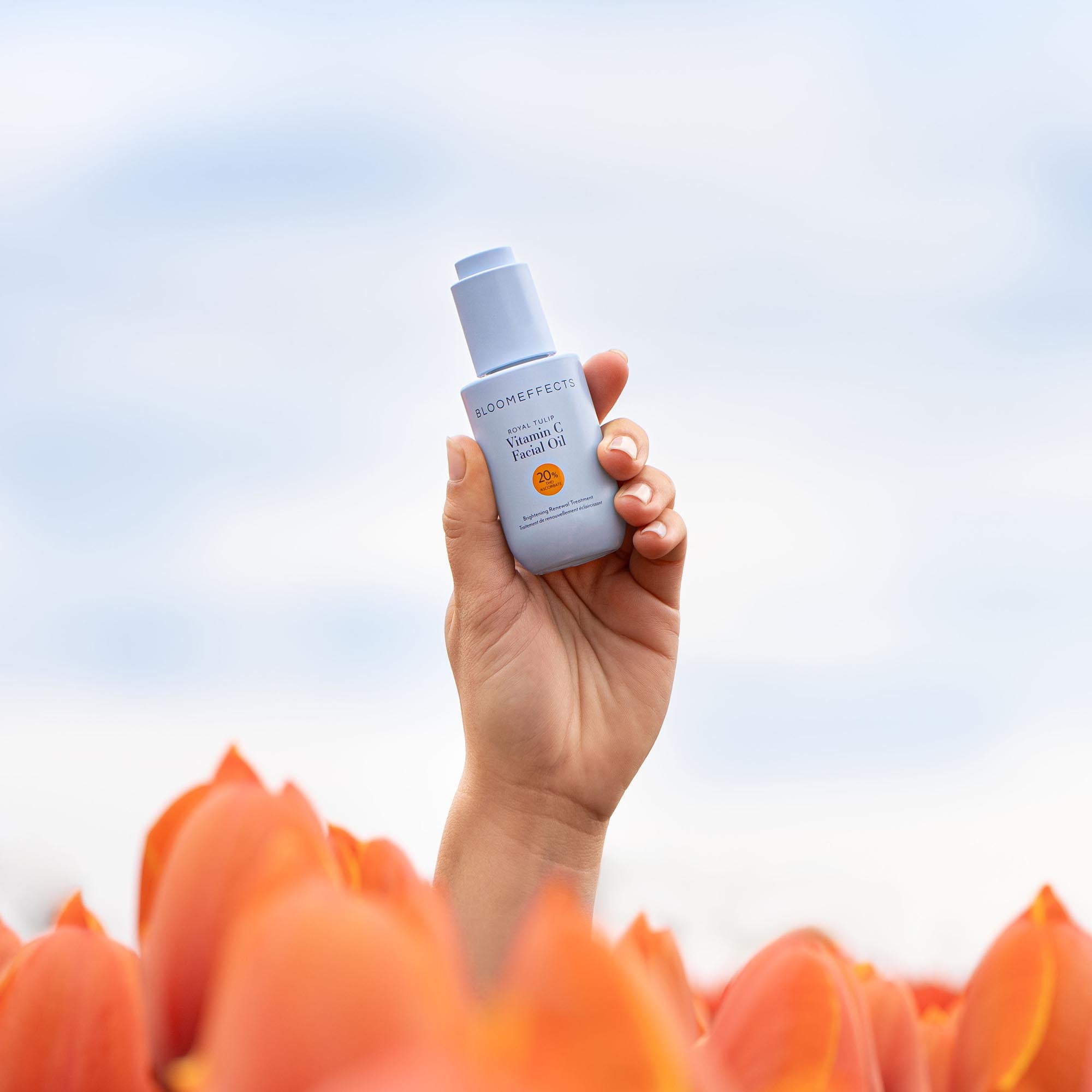Vitamin C Facial Oil in hand in a tulip field

